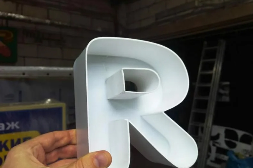 Объемные буквы полностью изготавливают из ПВХ пластика. Фронтальную часть фрезеруют, и в получившиеся отверстия вставляют светодиоды или другие лампы. Торцы и лицевую панель оклеивают пленкой Oracal.