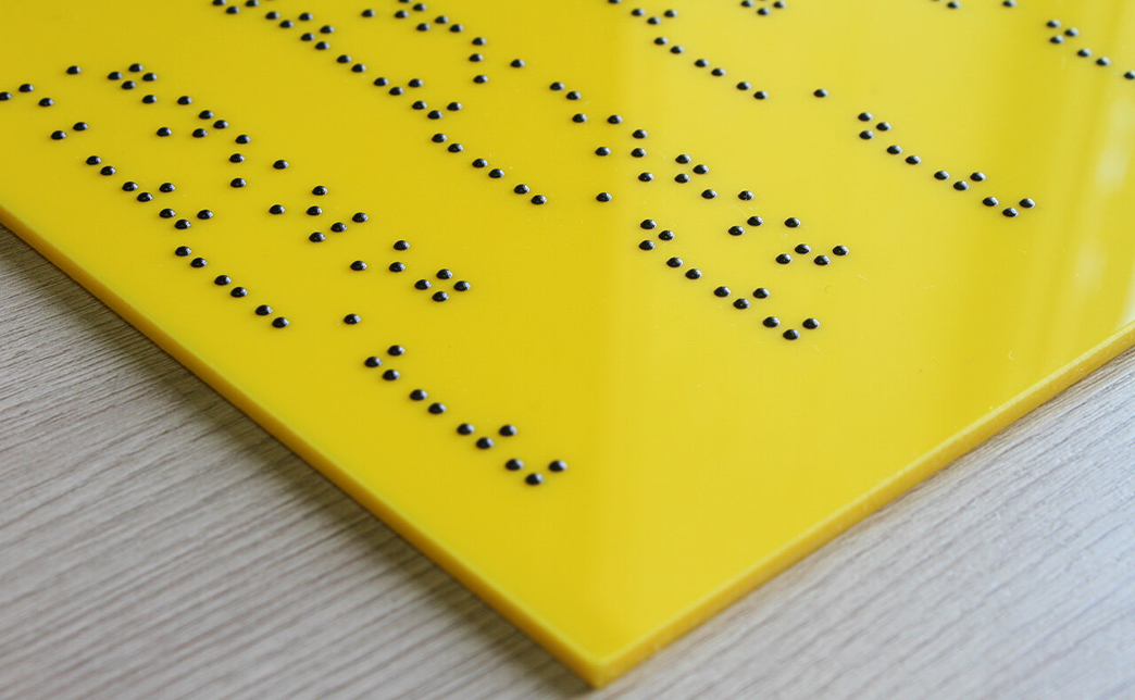 Чтобы тактильную табличку мог прочитать слабовидящий человек, необходимо создать контраст между тактильными элементами и фоном. Рекомендуется выбирать спокойные, неяркие цвета и избегать пестрых или переливающихся поверхностей.