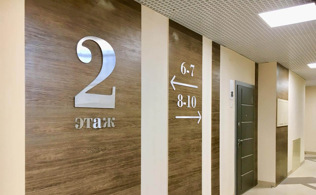 Антивандальные наклейки легко срывают, поэтому для общественных мест понадобятся цифры из металла или акрила с креплением на винты. Еще более прочные материалы — поликарбонат и композиты. Если существует проблема граффити, наносят специальный защитный лак. От выцветания на солнце помогут УФ-защищенные материалы.